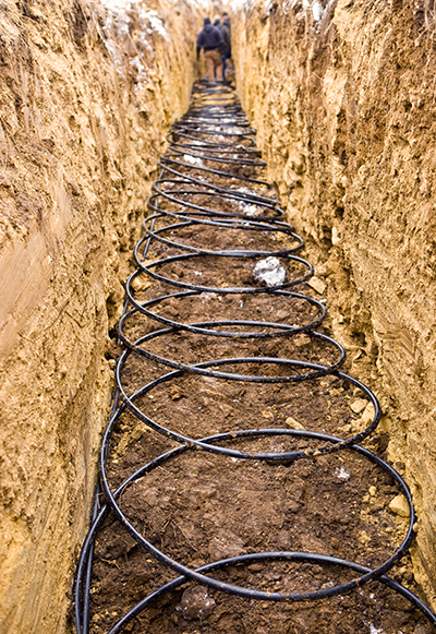Workers Laying Geothermal Coils in an Underground Trench